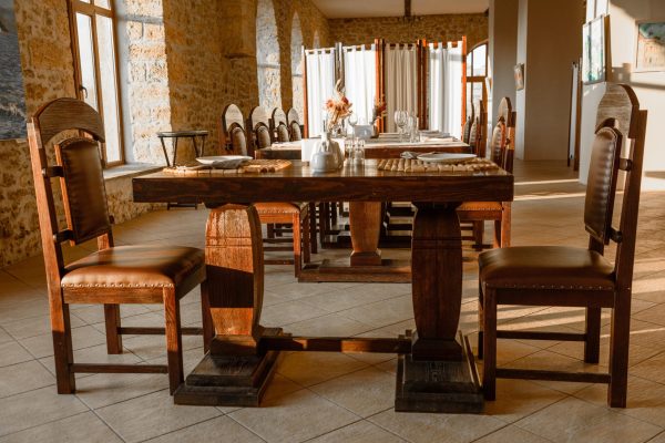 Glasses, flower fork, knife served for dinner in restaurant with cozy interior. Empty glasses in restaurant